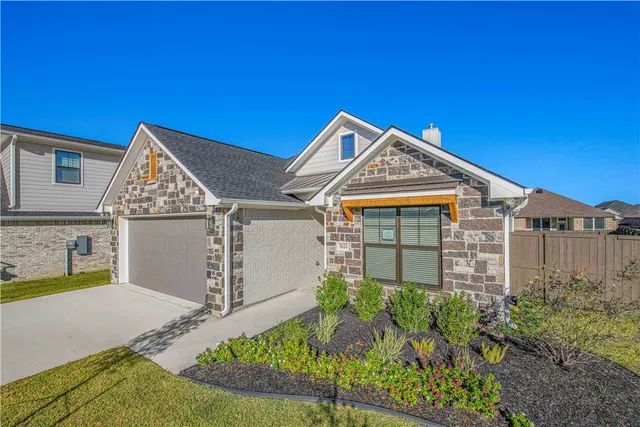 a view of a house with a small yard and plants