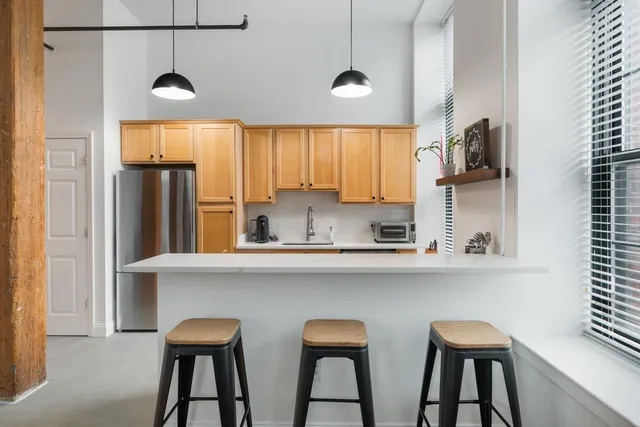 a kitchen with stainless steel appliances a table and chairs in it