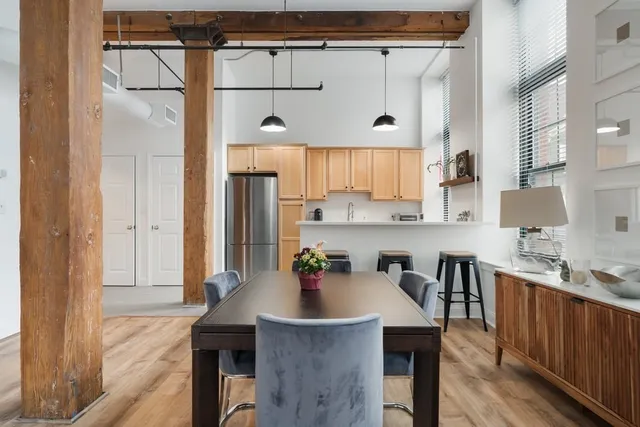 a kitchen with stainless steel appliances a table chairs and chandelier