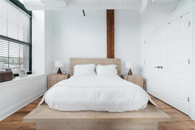 a bedroom with a bed and a large window