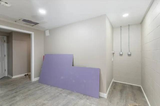 a view of a hallway with wooden floor and a bathroom