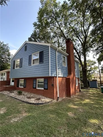 a front view of a house with a garden and tree
