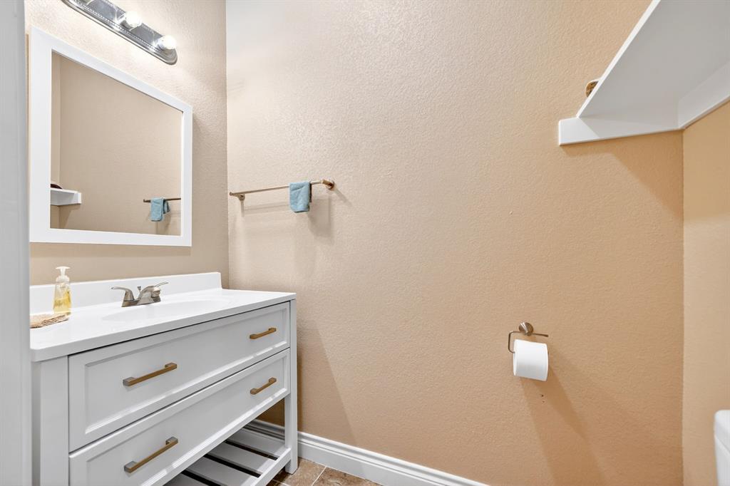 5230 Esquire Estates Road Mabank, TX 75156 - Photo 15 of 39 White vanity with brushed brass hardware, a white countertop, and an undermount sink
