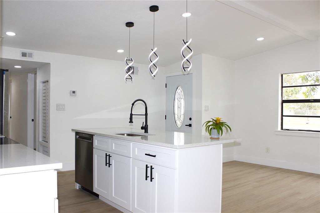 8816 Ashman Road Riverview, FL 33578 - Photo 15 of 52 a kitchen with kitchen island granite countertop a sink a counter space and cabinets