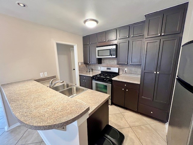 8006 Pinedale Cove Austin, TX 78757 - Photo 5 of 22 a kitchen with stainless steel appliances granite countertop a sink refrigerator and microwave