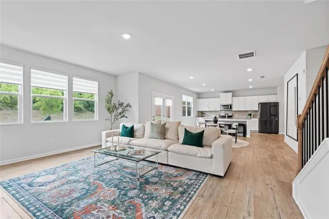 a living room with furniture and a wooden floor