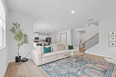 a living room with furniture and a wooden floor