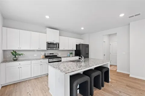 a kitchen with granite countertop a sink stove and refrigerator