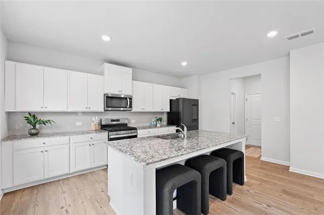 a kitchen with granite countertop a sink stove and refrigerator