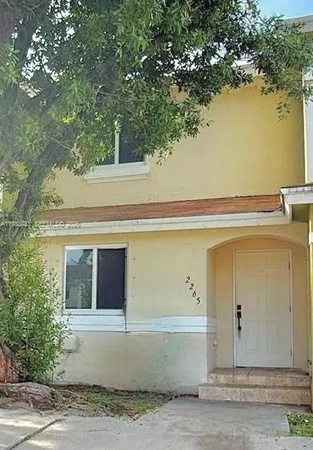 a front view of a house with trees