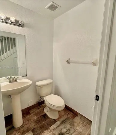 a bathroom with a sink toilet and mirror