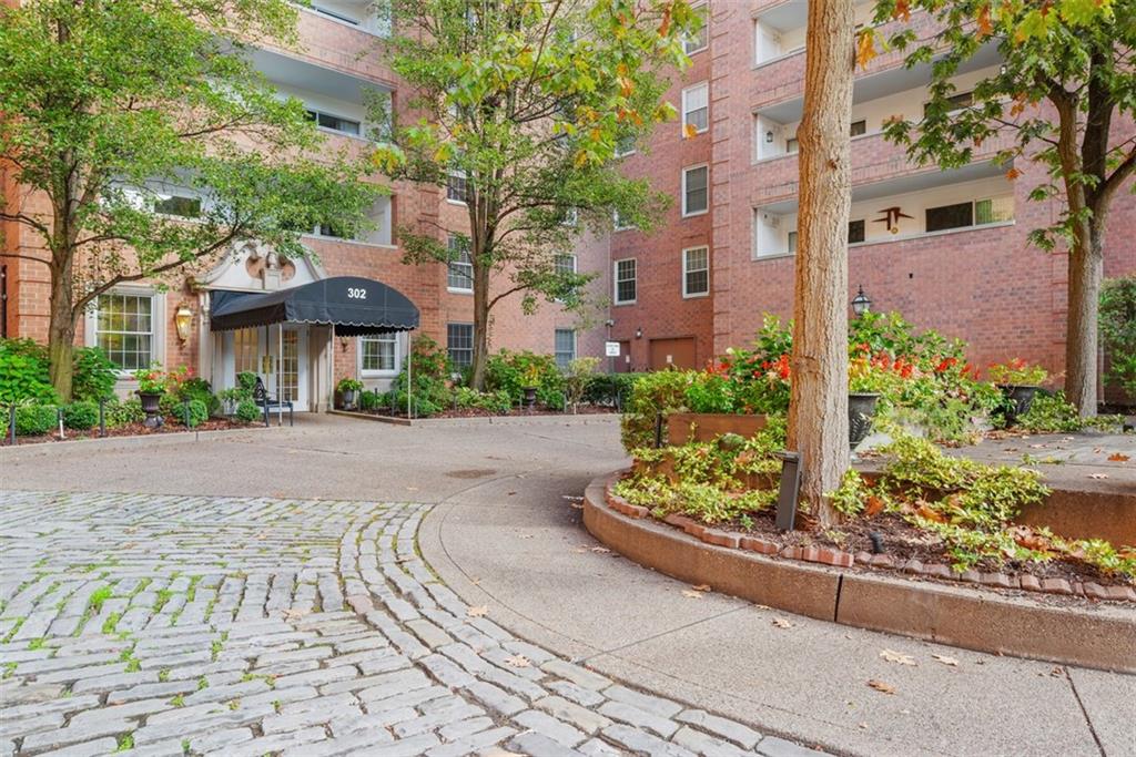 302 Fox Chapel Road, Unit 613 Pittsburgh, PA 15238 - Photo 2 of 37 a front view of a house with a yard and a garden