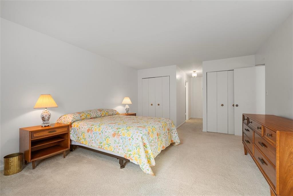 302 Fox Chapel Road, Unit 613 Pittsburgh, PA 15238 - Photo 22 of 37 a spacious bedroom with a bed and a lamp
