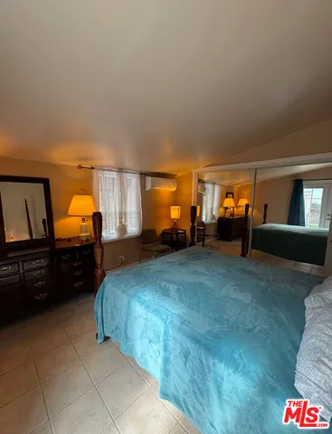 a bedroom with a bed and dresser with mirror