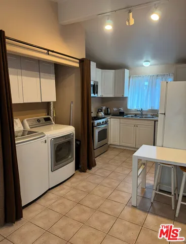 a kitchen with stainless steel appliances granite countertop a stove top oven a sink and a refrigerator