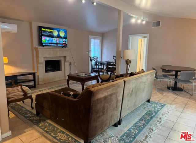 a living room with furniture a fireplace and a flat screen tv