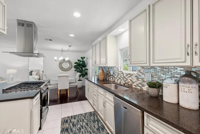 a kitchen with stainless steel appliances granite countertop a sink stove and cabinets