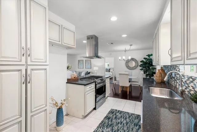 a kitchen with stainless steel appliances granite countertop a sink stove and cabinets