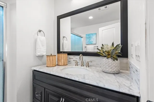 a bathroom with a granite countertop sink and a mirror