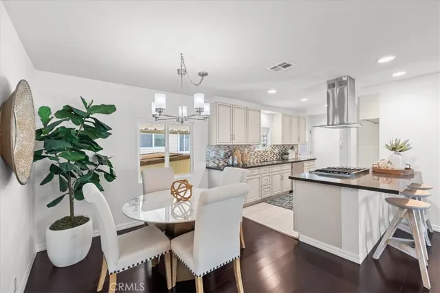 a kitchen with stainless steel appliances kitchen island a table and chairs in it