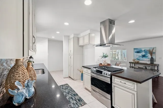 a kitchen with stainless steel appliances granite countertop a stove a sink and a refrigerator