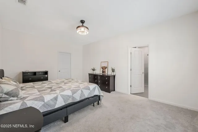 a bedroom with a bed and a dresser next to a window