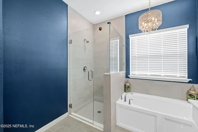 a view of a patio with couches potted plants and a floor to ceiling window