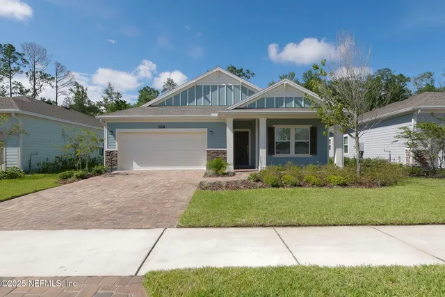 a front view of a house with a yard and potted plants
