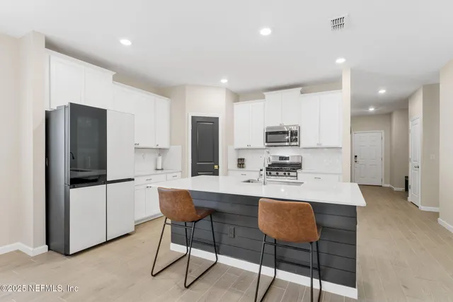 a kitchen with a stove a sink a table and chairs