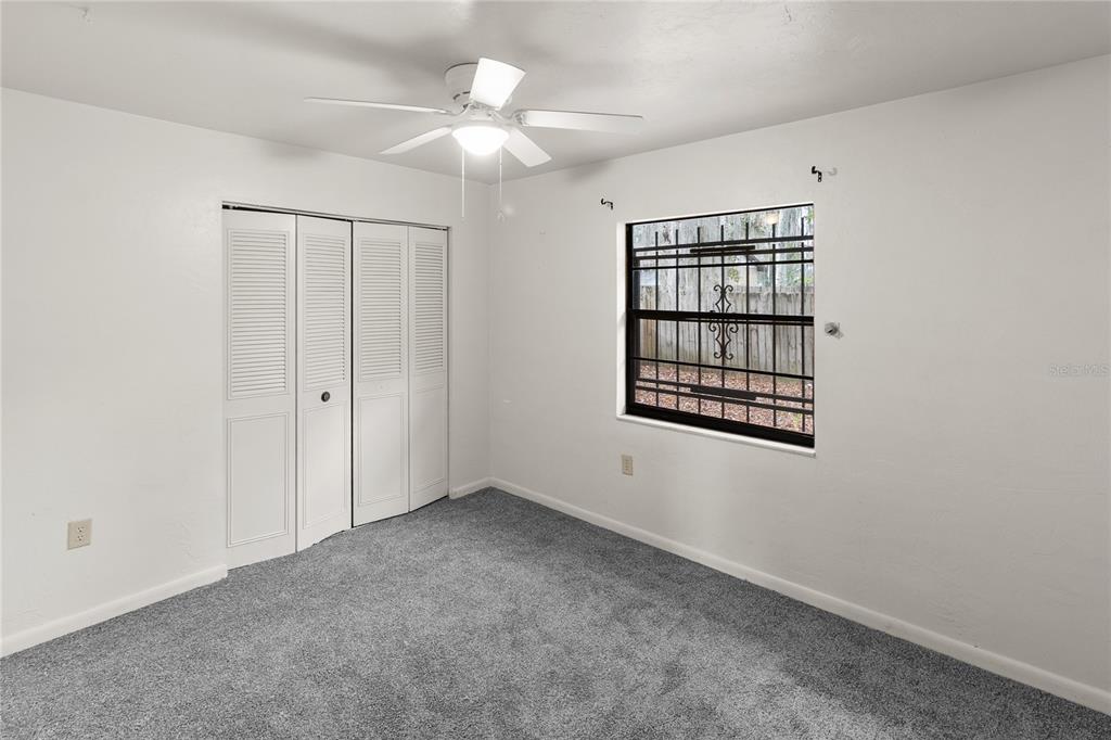 1018 Southwest 60 Terrace, Unit A Gainesville, FL 32607 - Photo 9 of 11 an empty room with windows and fan