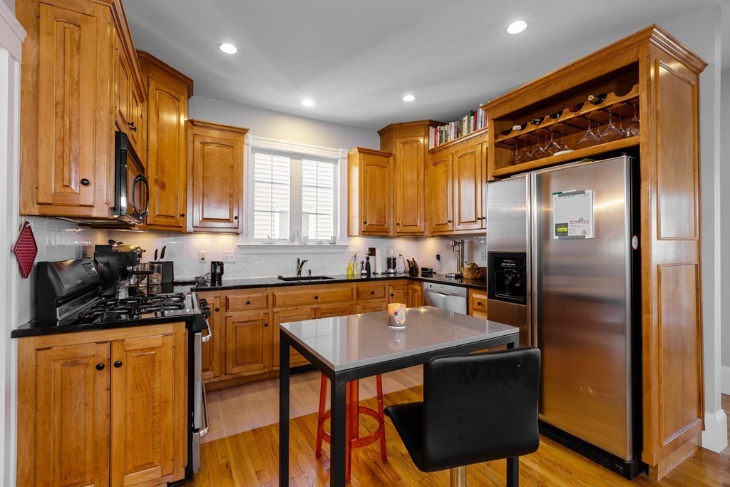 273-275 Concord Avenue, Unit 2 Cambridge, MA 02138 - Photo 7 of 24 a kitchen with stainless steel appliances a stove a refrigerator and wooden cabinets