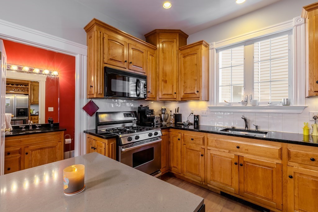 273-275 Concord Avenue, Unit 2 Cambridge, MA 02138 - Photo 8 of 24 a kitchen with stainless steel appliances granite countertop a stove a sink and a microwave