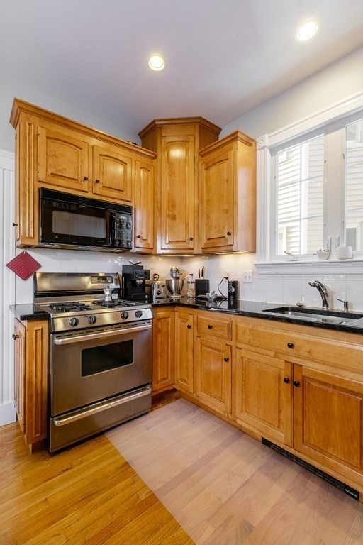 273-275 Concord Avenue, Unit 2 Cambridge, MA 02138 - Photo 9 of 24 a kitchen with stainless steel appliances granite countertop a stove and a sink