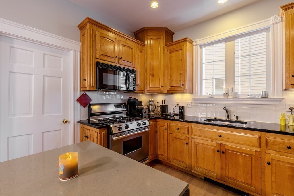 273-275 Concord Avenue, Unit 2 Cambridge, MA 02138 - Photo 10 of 24 a kitchen with stainless steel appliances granite countertop a stove a sink and a microwave