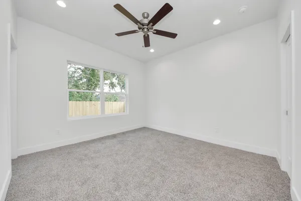 wooden floor in an empty room and a ceiling fan