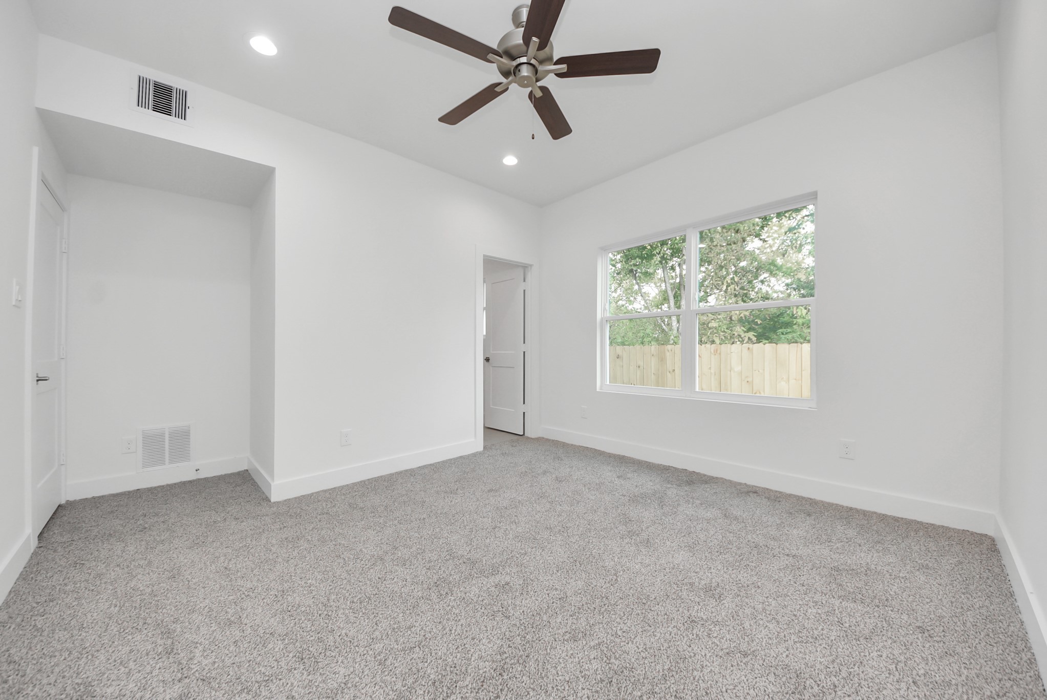 611 East 39th Street, Unit D Houston, TX 77022 - Photo 18 of 33 an empty room with windows and ceiling fan