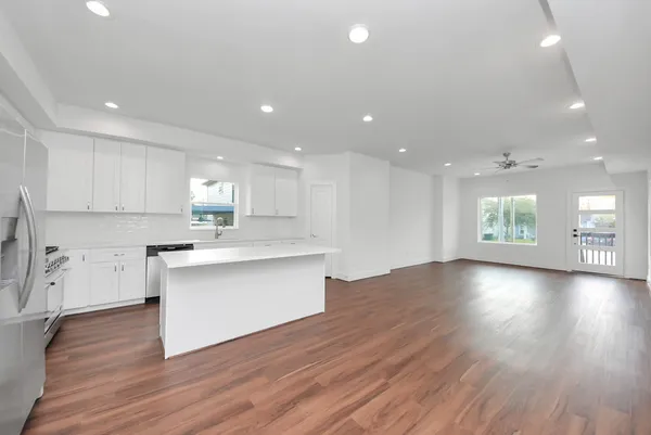 a kitchen with a sink a refrigerator and white cabinets