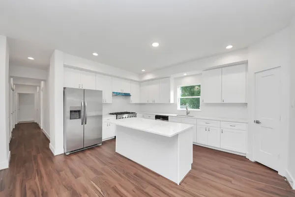 a kitchen with stainless steel appliances a stove a sink and a refrigerator
