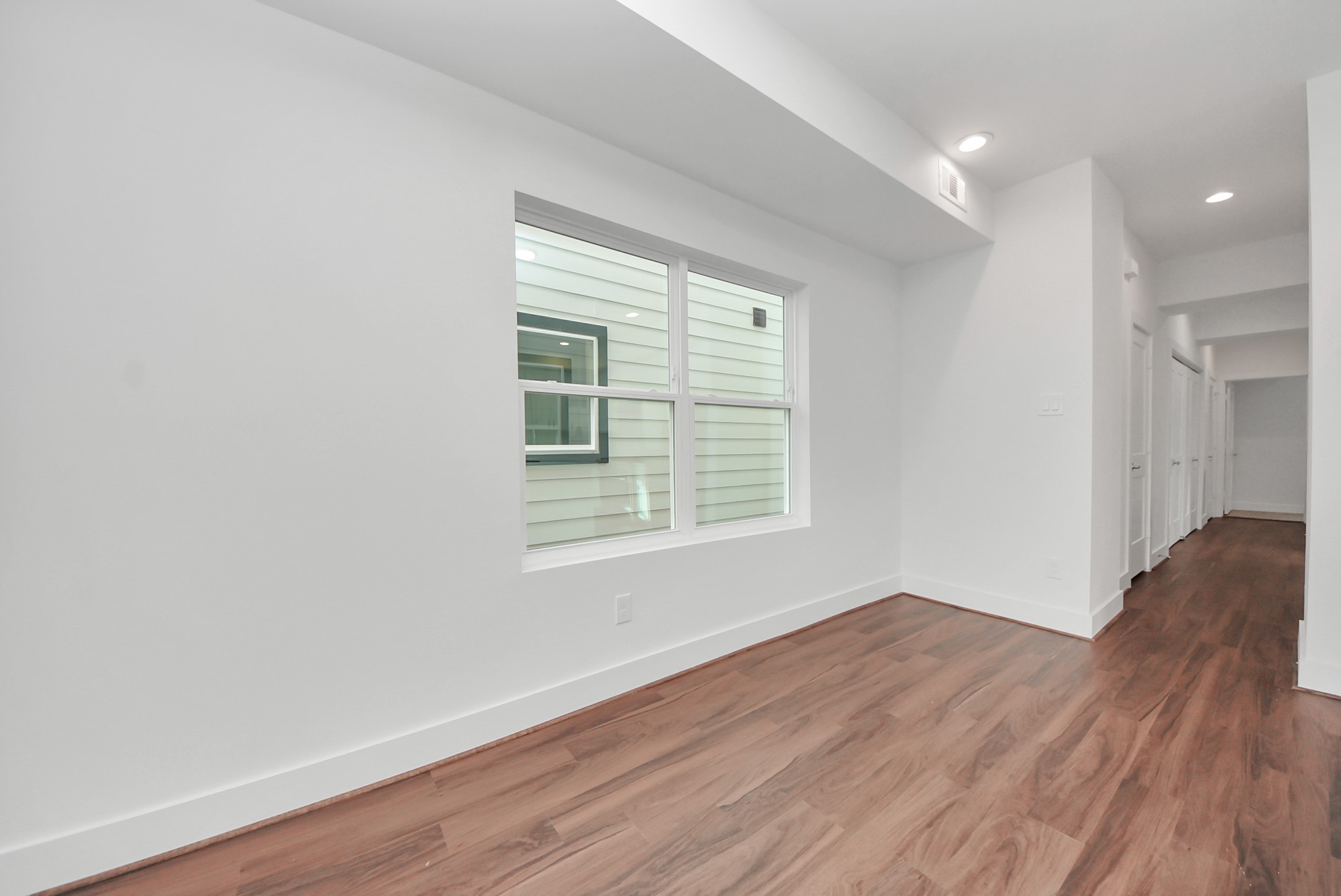 611 East 39th Street, Unit D Houston, TX 77022 - Photo 10 of 33 an empty room with wooden floor and windows