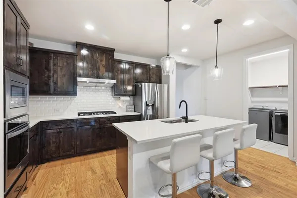 a large kitchen with a table and chairs