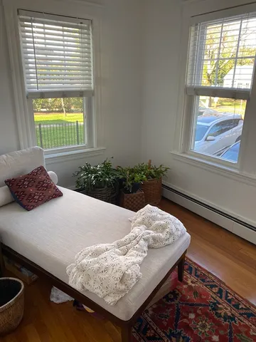 a wooden floor in a bedroom next to a window