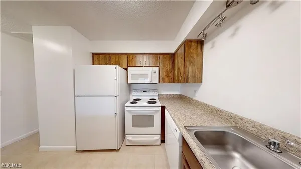 a kitchen with a refrigerator sink stove and oven