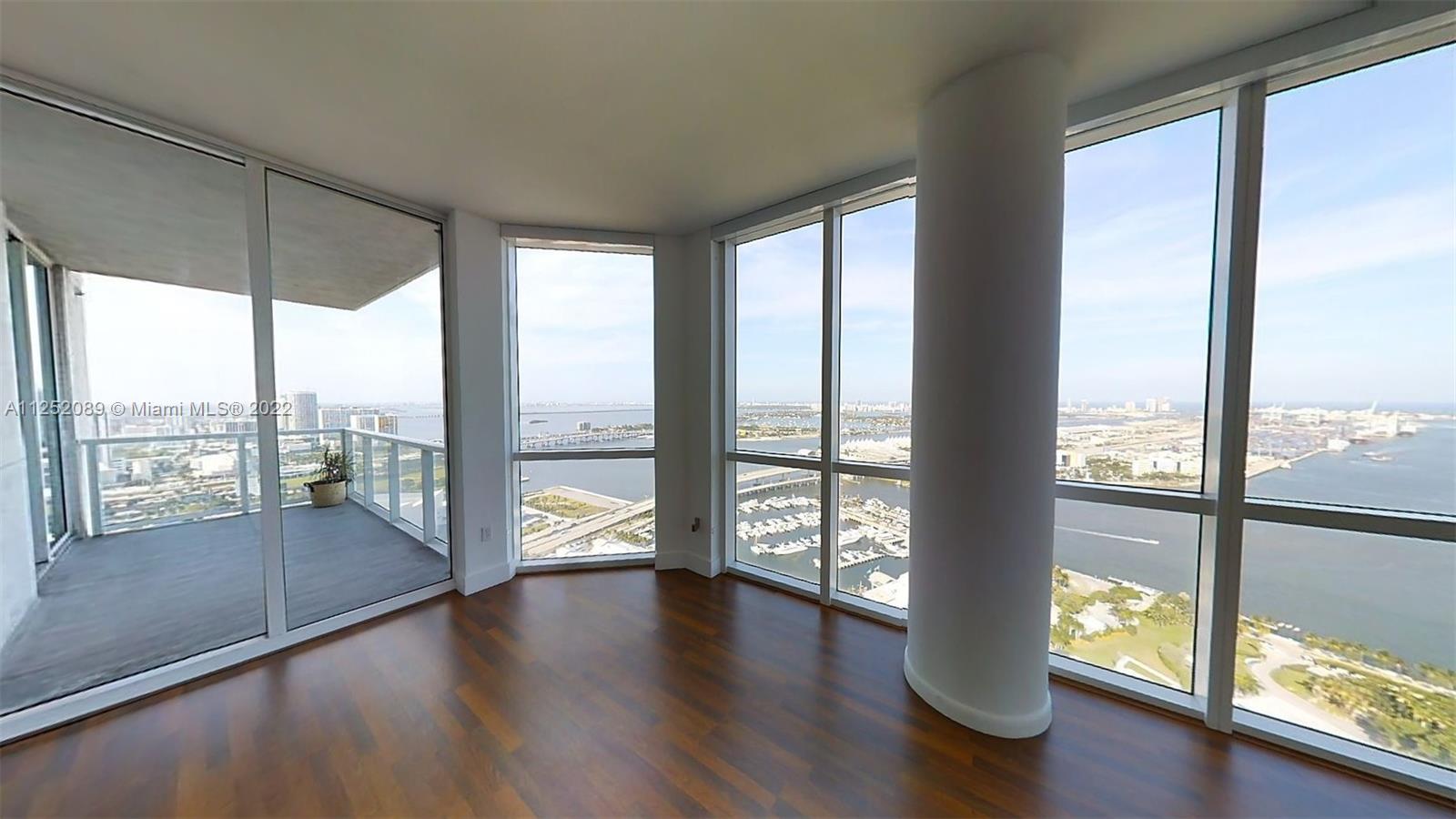 244 Biscayne Boulevard, Unit 4503 Miami, FL 33132 - Photo 11 of 33 a view of an empty room with wooden floor and a large window