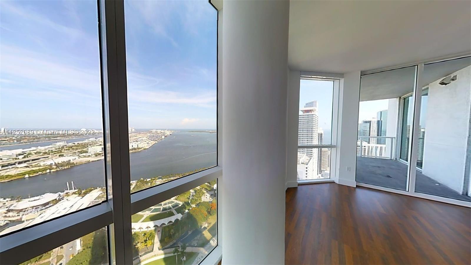 244 Biscayne Boulevard, Unit 4503 Miami, FL 33132 - Photo 12 of 33 a view of an empty room with wooden floor and windows