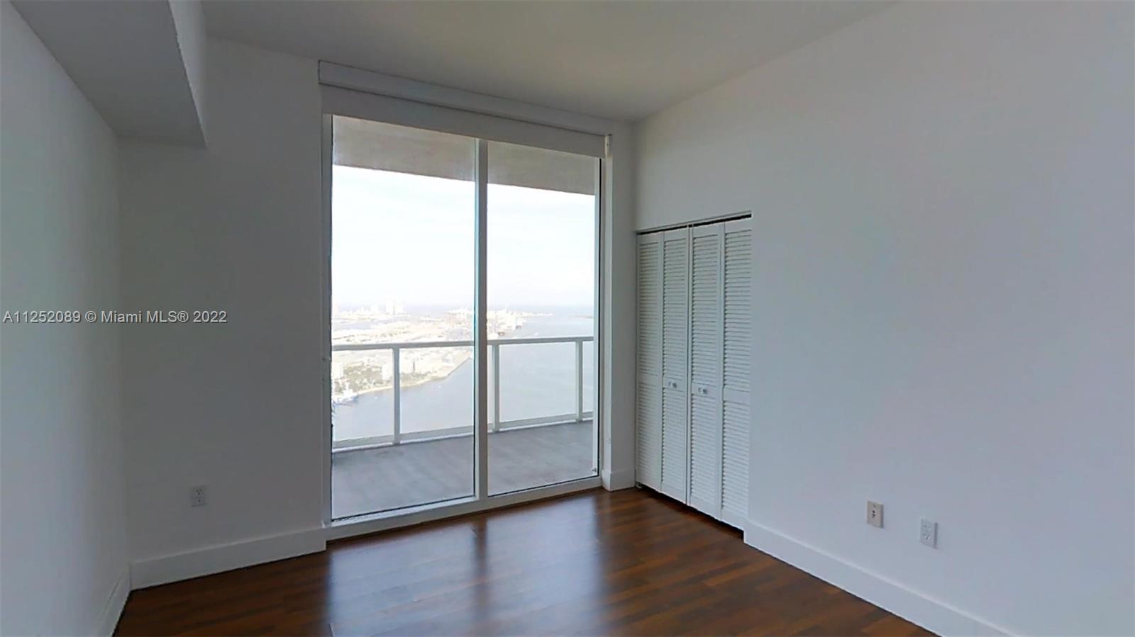 244 Biscayne Boulevard, Unit 4503 Miami, FL 33132 - Photo 22 of 33 an empty room with wooden floor and windows