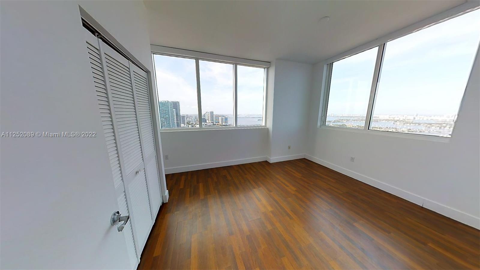 244 Biscayne Boulevard, Unit 4503 Miami, FL 33132 - Photo 28 of 33 a view of an empty room with wooden floor and a window