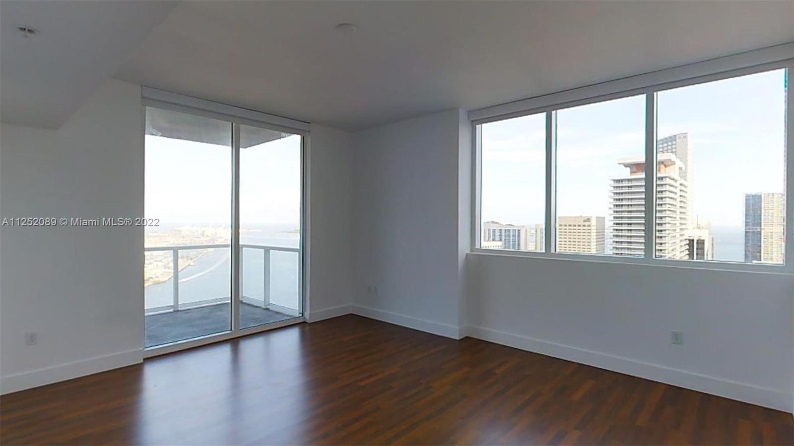 244 Biscayne Boulevard, Unit 4503 Miami, FL 33132 - Photo 30 of 33 a view of an empty room with wooden floor and a window