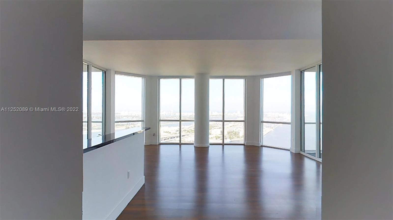 244 Biscayne Boulevard, Unit 4503 Miami, FL 33132 - Photo 3 of 33 a view of an empty room with wooden floor and a window