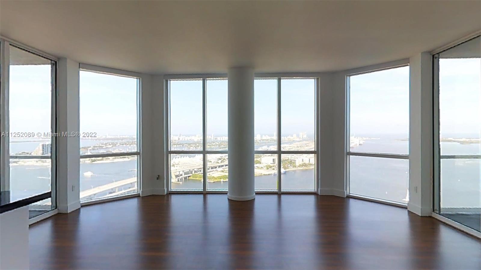 244 Biscayne Boulevard, Unit 4503 Miami, FL 33132 - Photo 4 of 33 a view of an empty room with wooden floor and a window