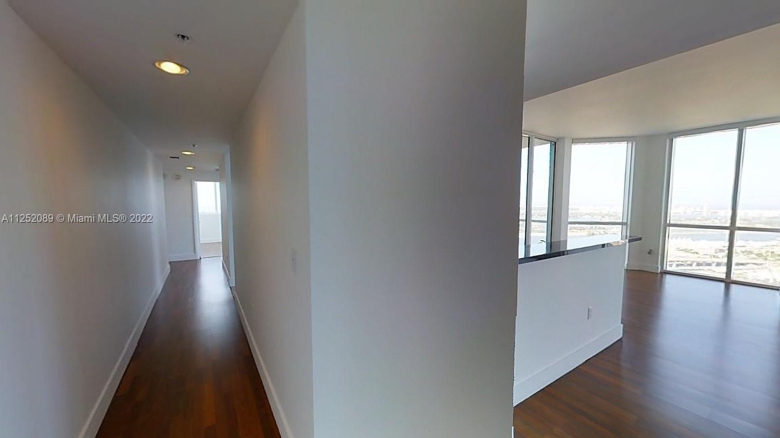 244 Biscayne Boulevard, Unit 4503 Miami, FL 33132 - Photo 7 of 33 wooden floor in an empty room with a window